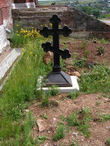 Рядом с храмом у самой его стены стоит крест.